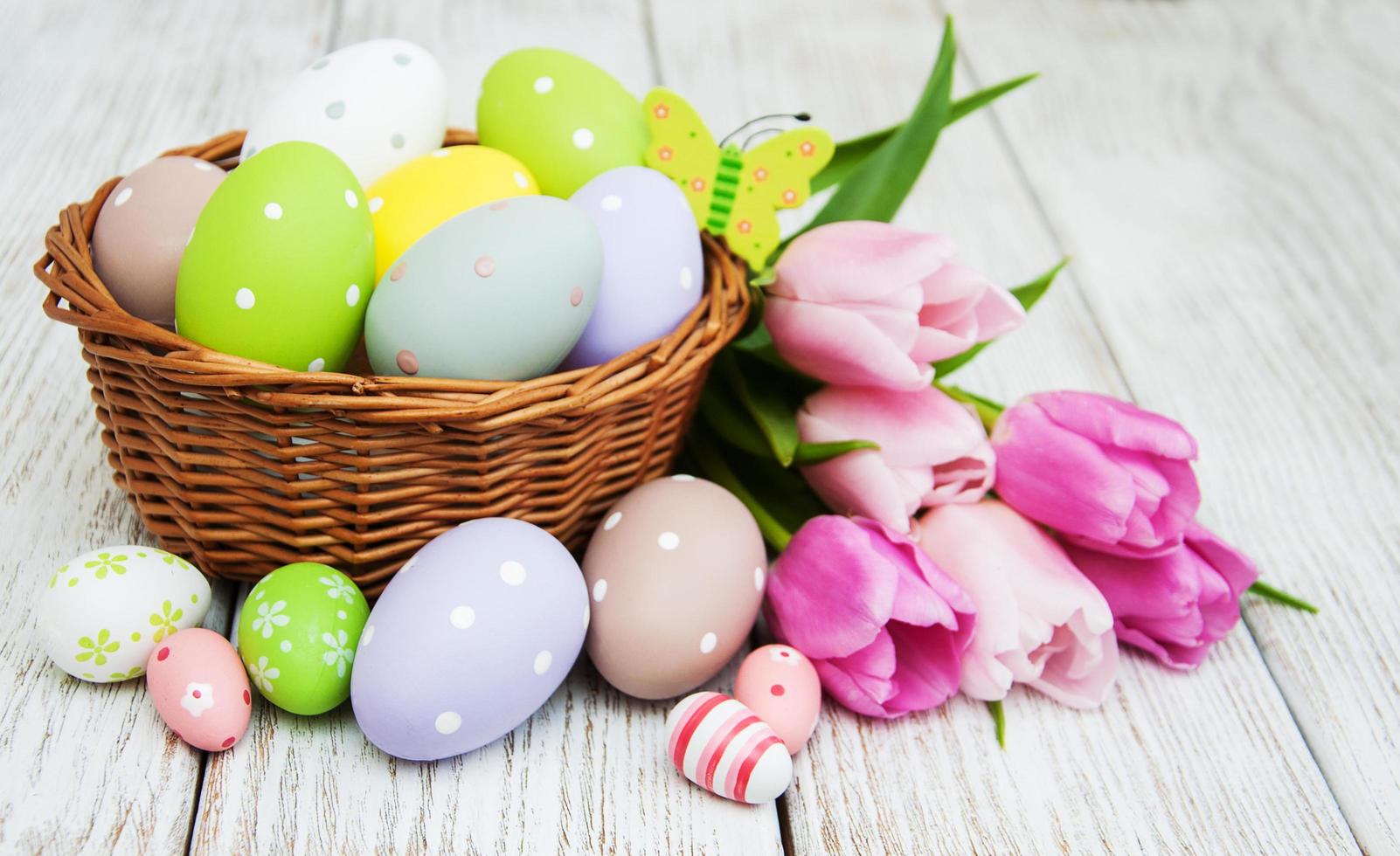 Basket with easter eggs and tulips photo