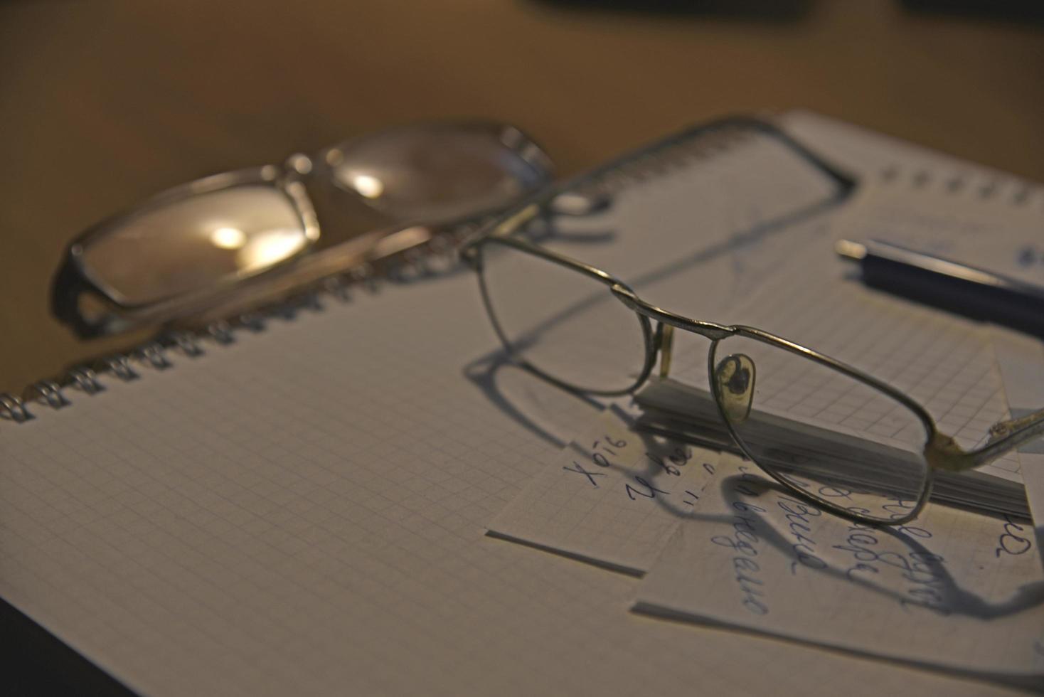 Notebook and glasses on the table in the evening photo