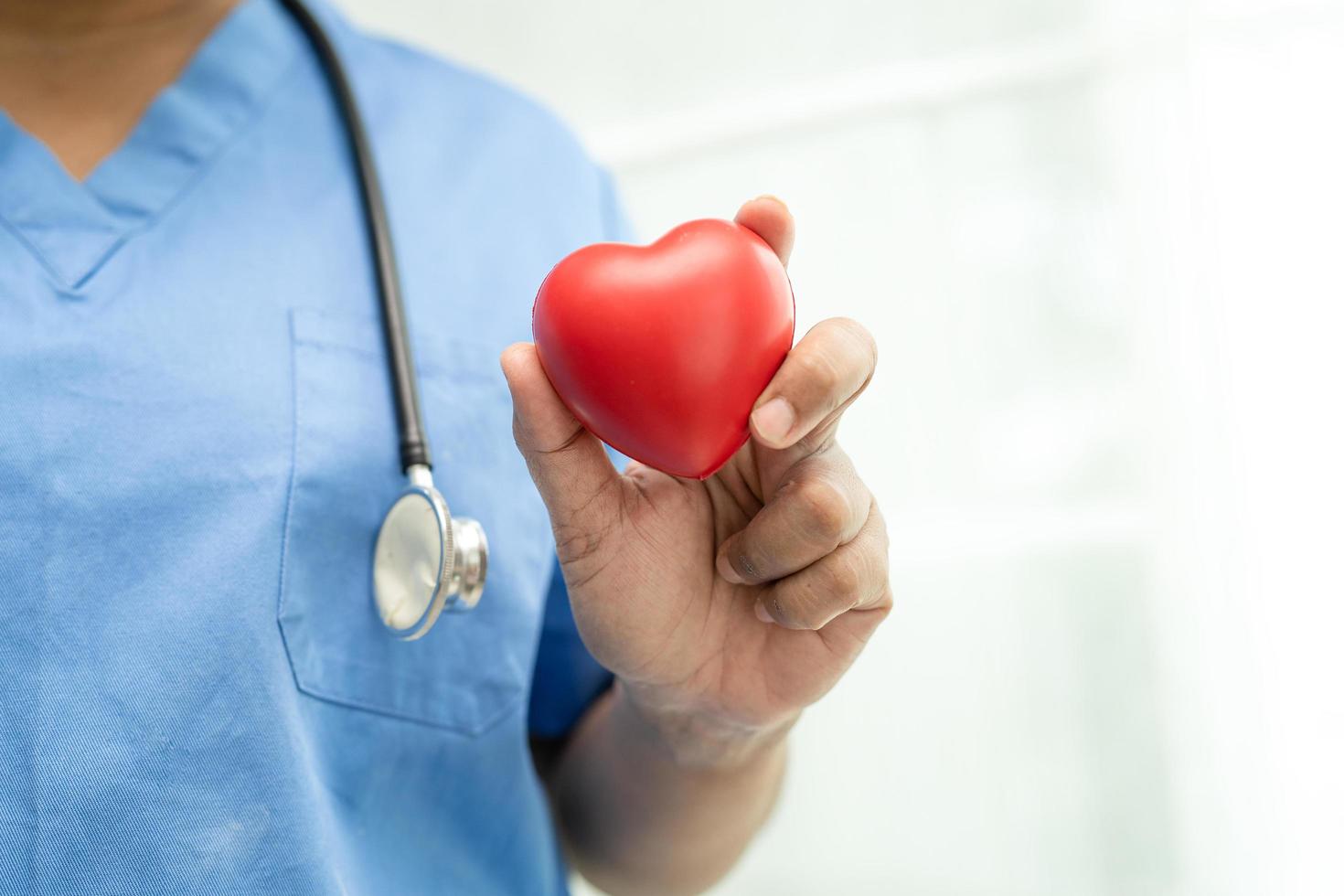 Asian senior or elderly old lady woman patient holding red heart in her hand on bed in nursing hospital ward, healthy strong medical concept photo