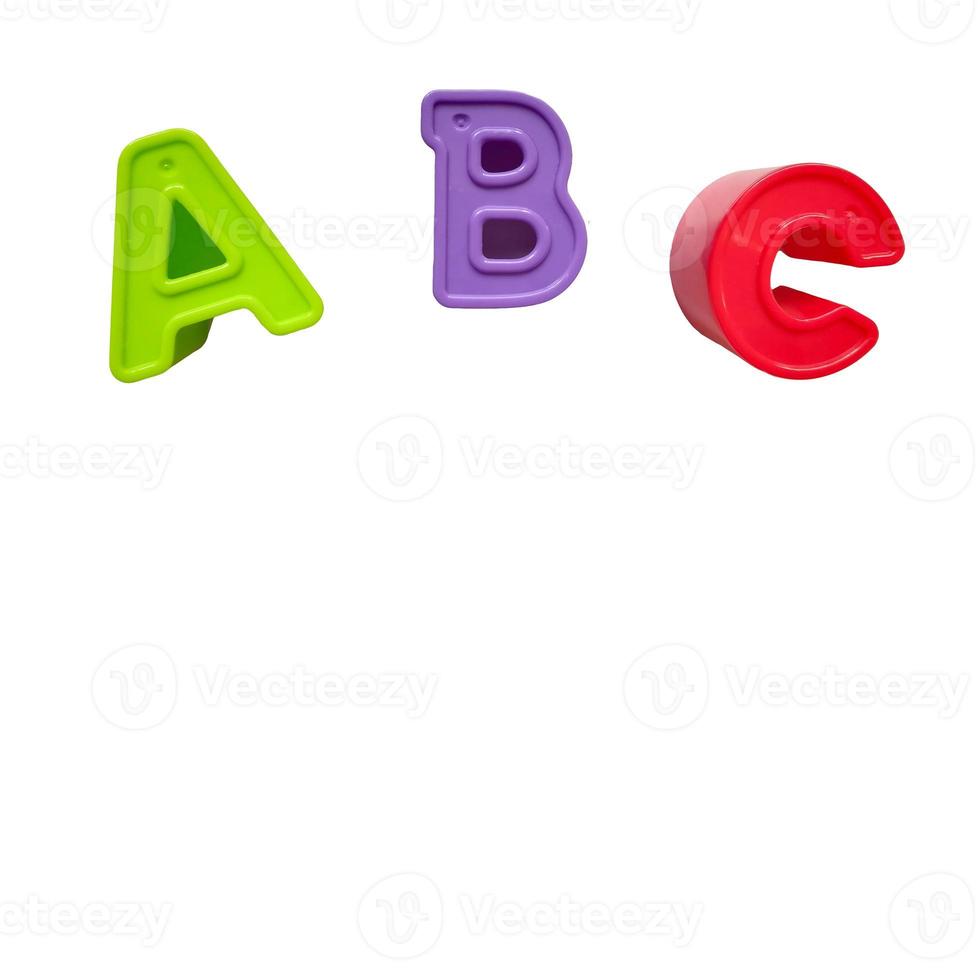 las letras de plástico multicolores a, b, c están aisladas en un fondo blanco. verde, morado, rojo, juguetes, alfabeto, lugar de aprendizaje para texto foto