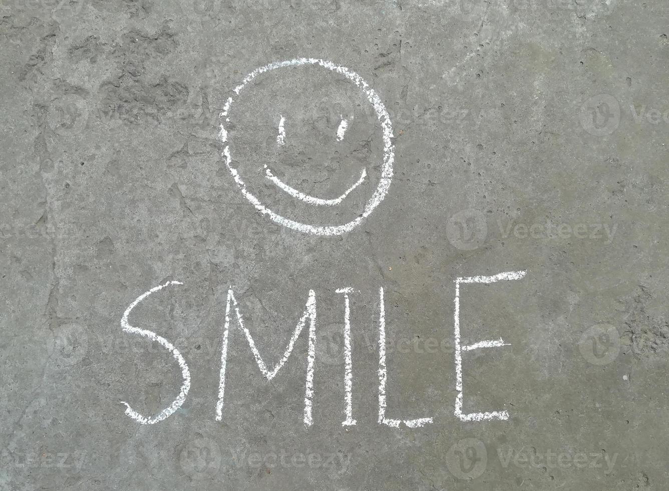 smile is drawn in chalk on the asphalt. children creativity, summer, joy emotion, happiness photo