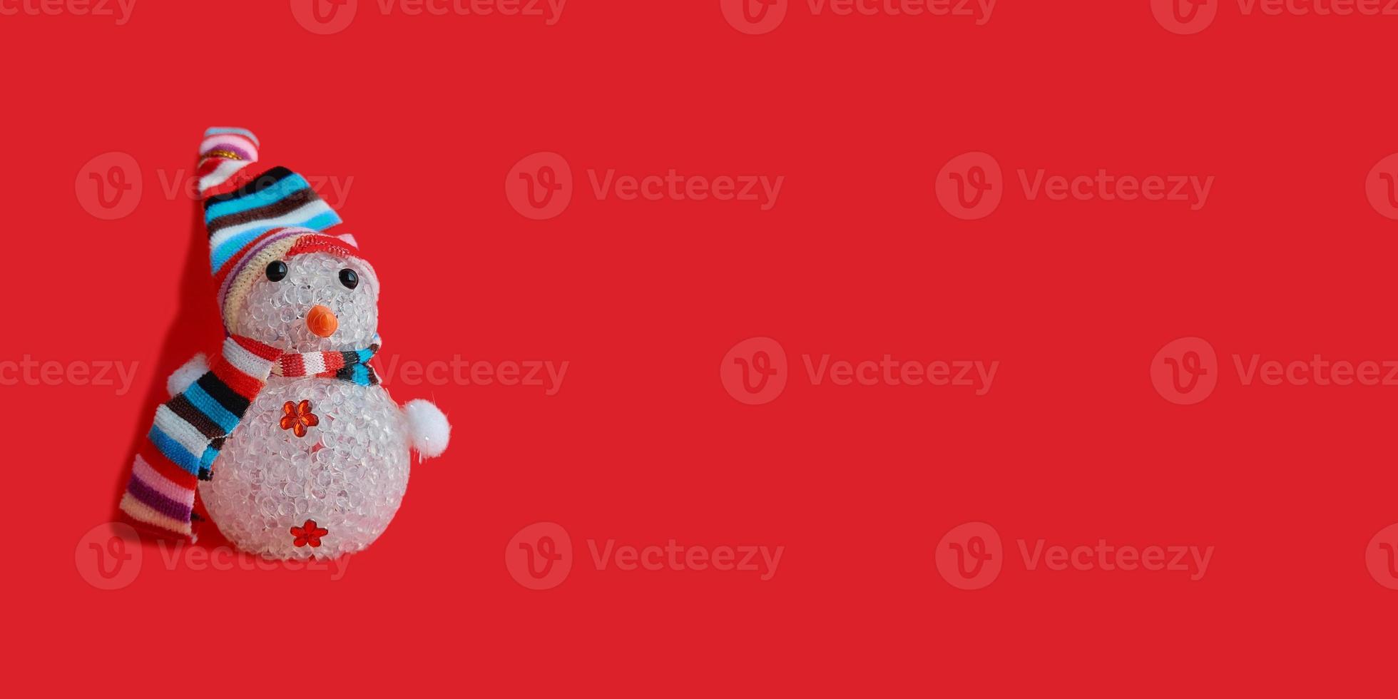 snowman in a striped hat and scarf on a red background. christmas decoration banner, horizontal, copy space, place for text. new year, holiday photo