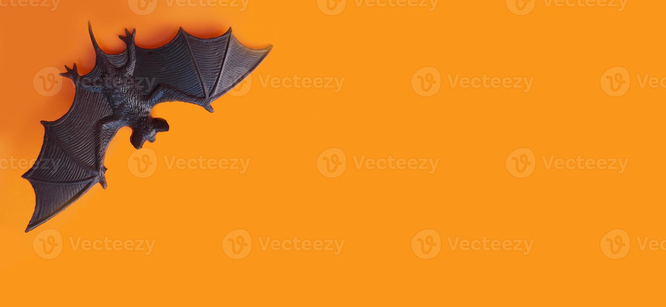 halloween banner. figurine of a bat on an orange background, copy space, place for text. animal, flyer, invitation photo