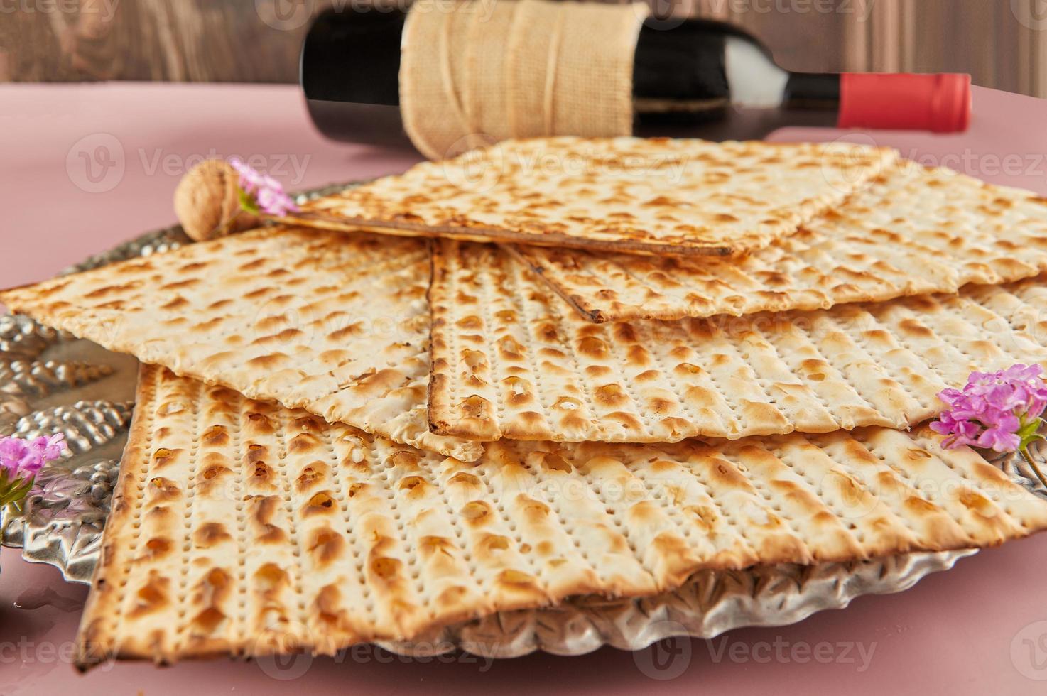 Pesach celebration concept - jewish Passover holiday. Matzah on Seder plate with bottle of red wine photo