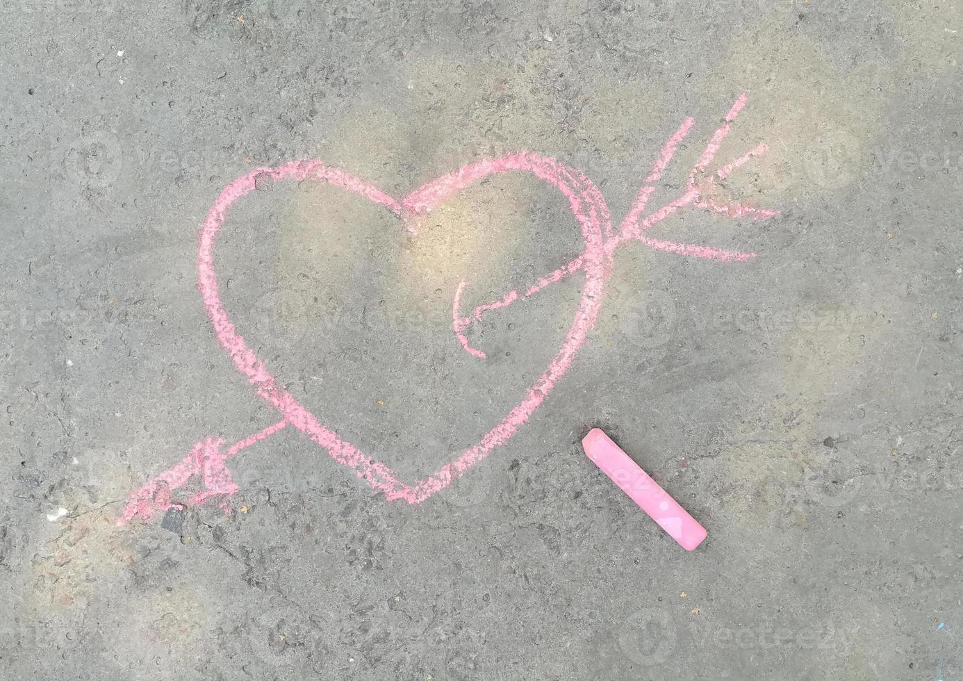 pink heart and arrow drawn with chalk on the asphalt. love confession. banner place for text, valentine, children creativity copy space, summer photo