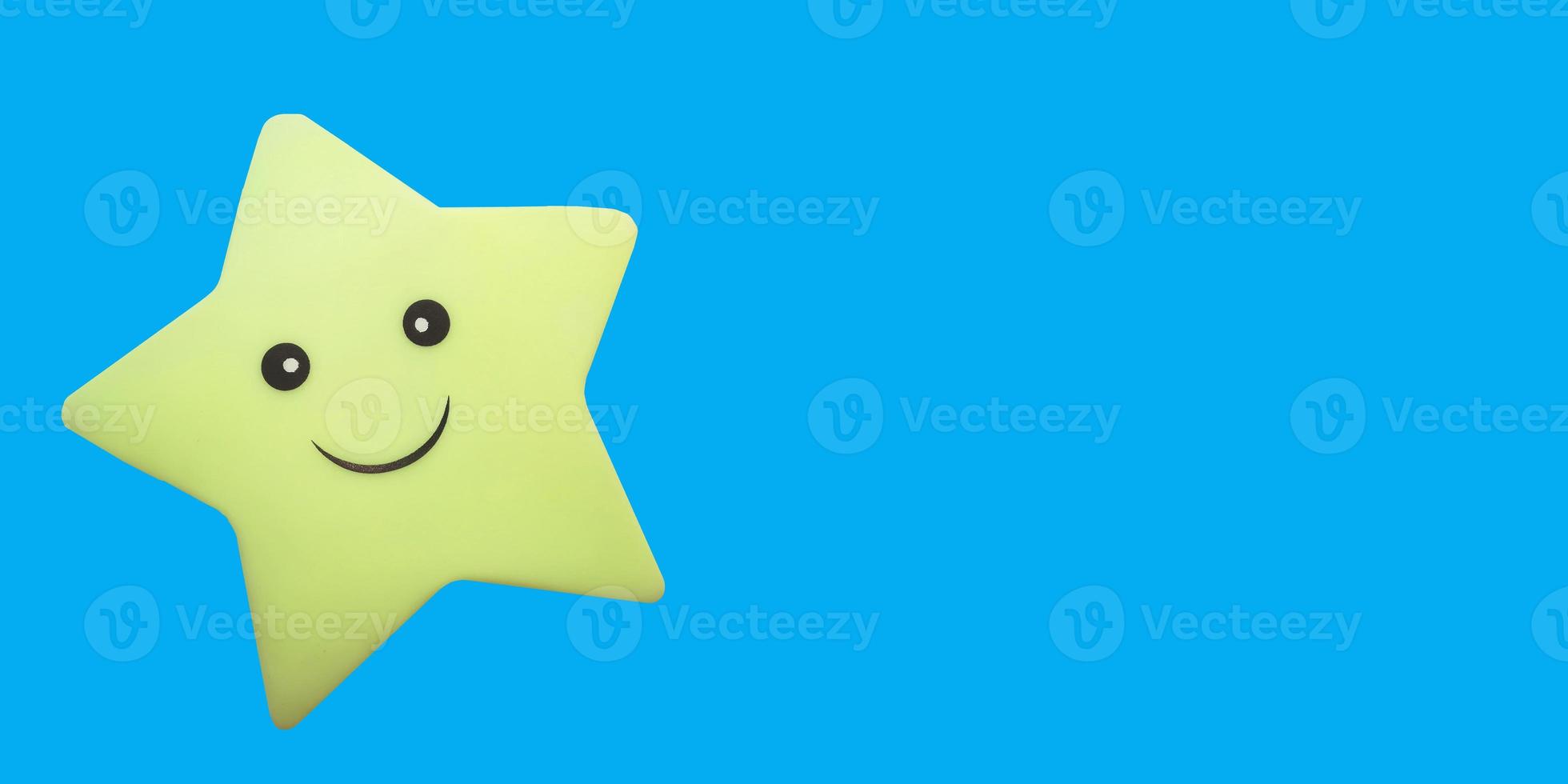 star toy with a smile on a blue background with place for text, copy space. fun kids banner, dream, night. photo