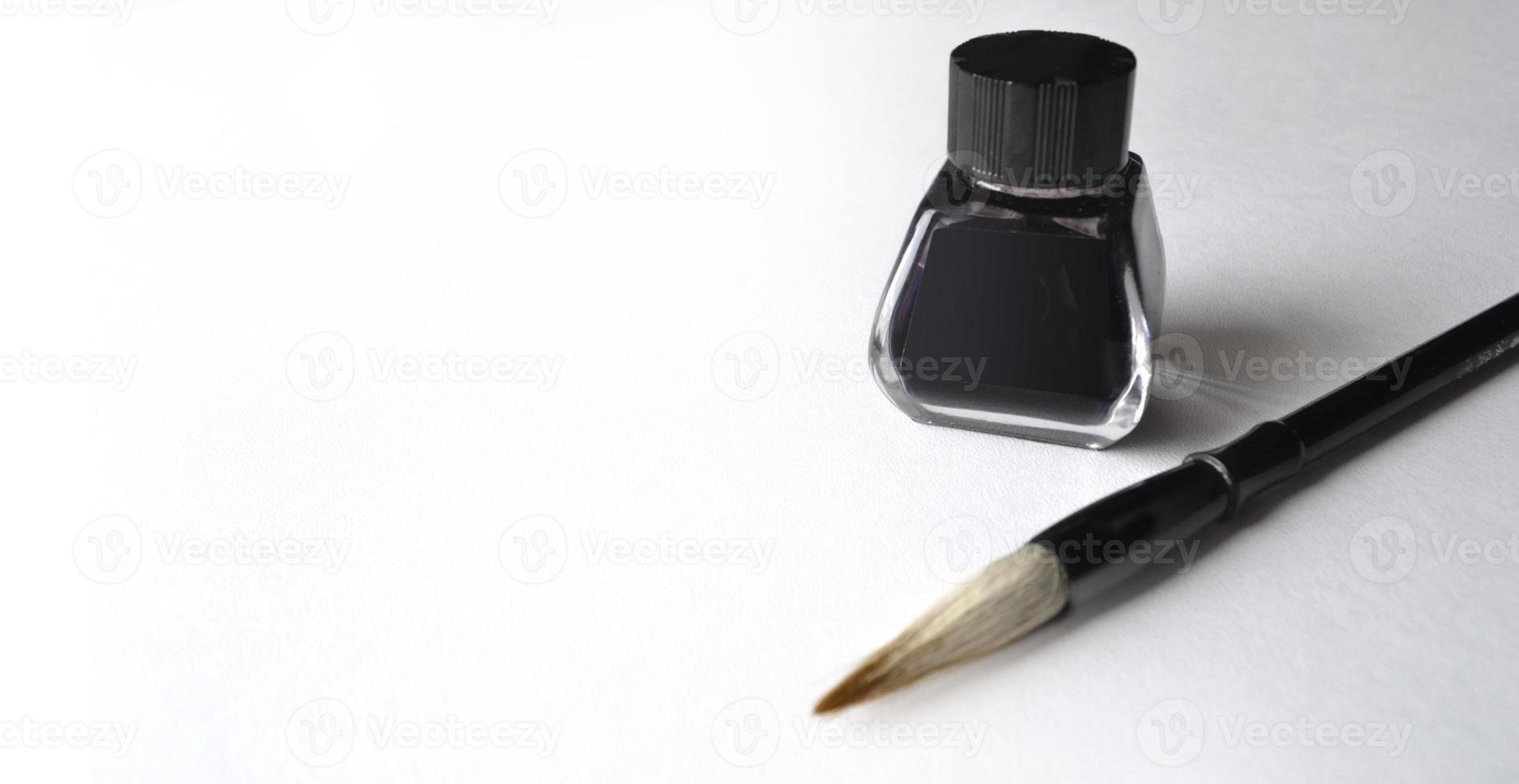 Ink bottle with brush for painting chinese painting on white photo