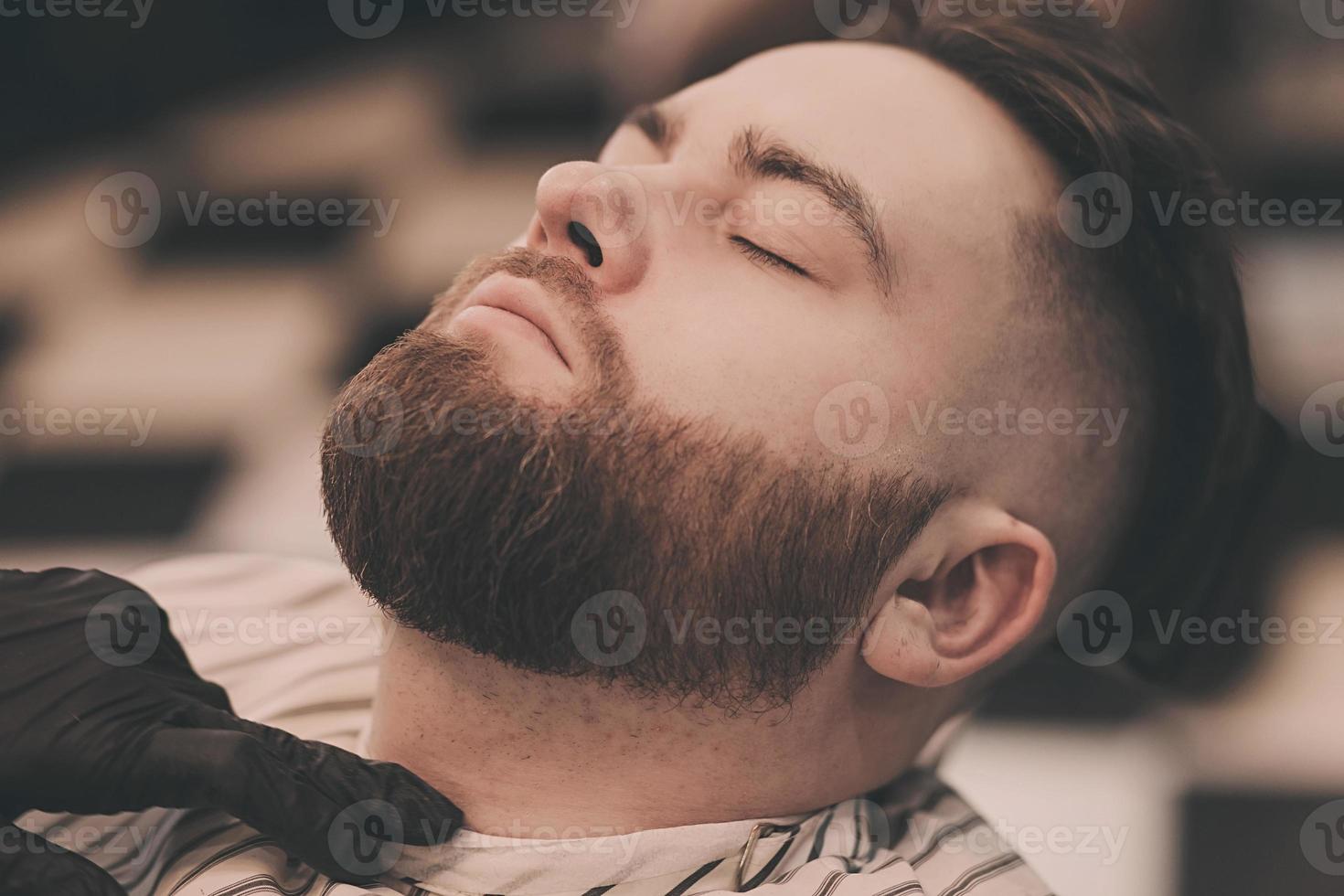 Man with beard in barber shop. photo