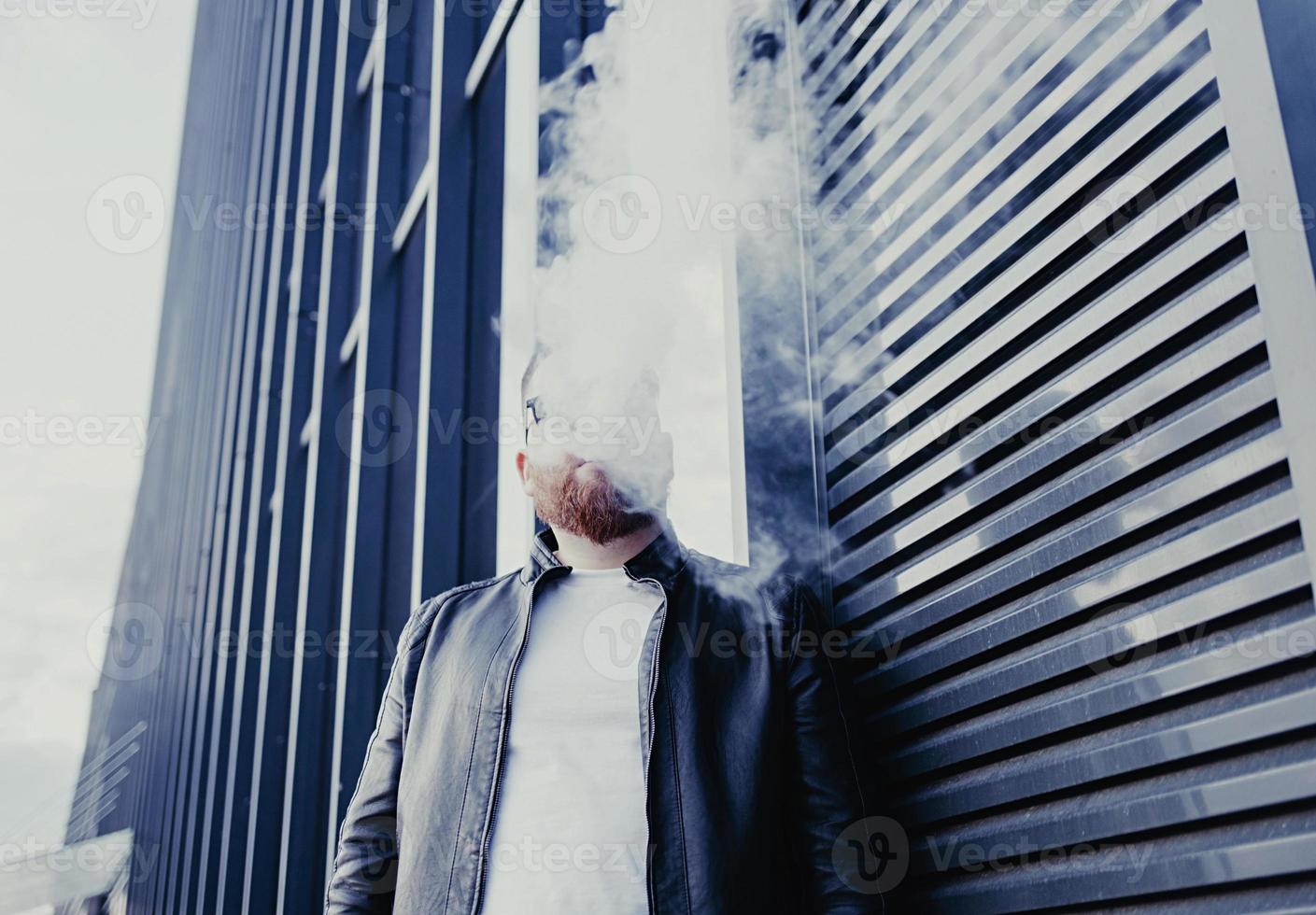 man smokes an electronic cigarette photo