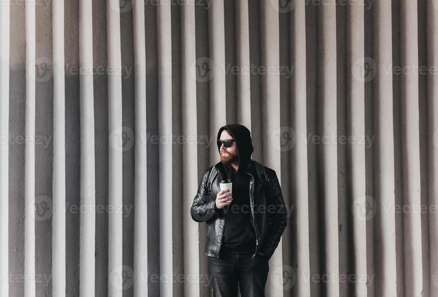 hipster man in sunglasses holding coffee photo