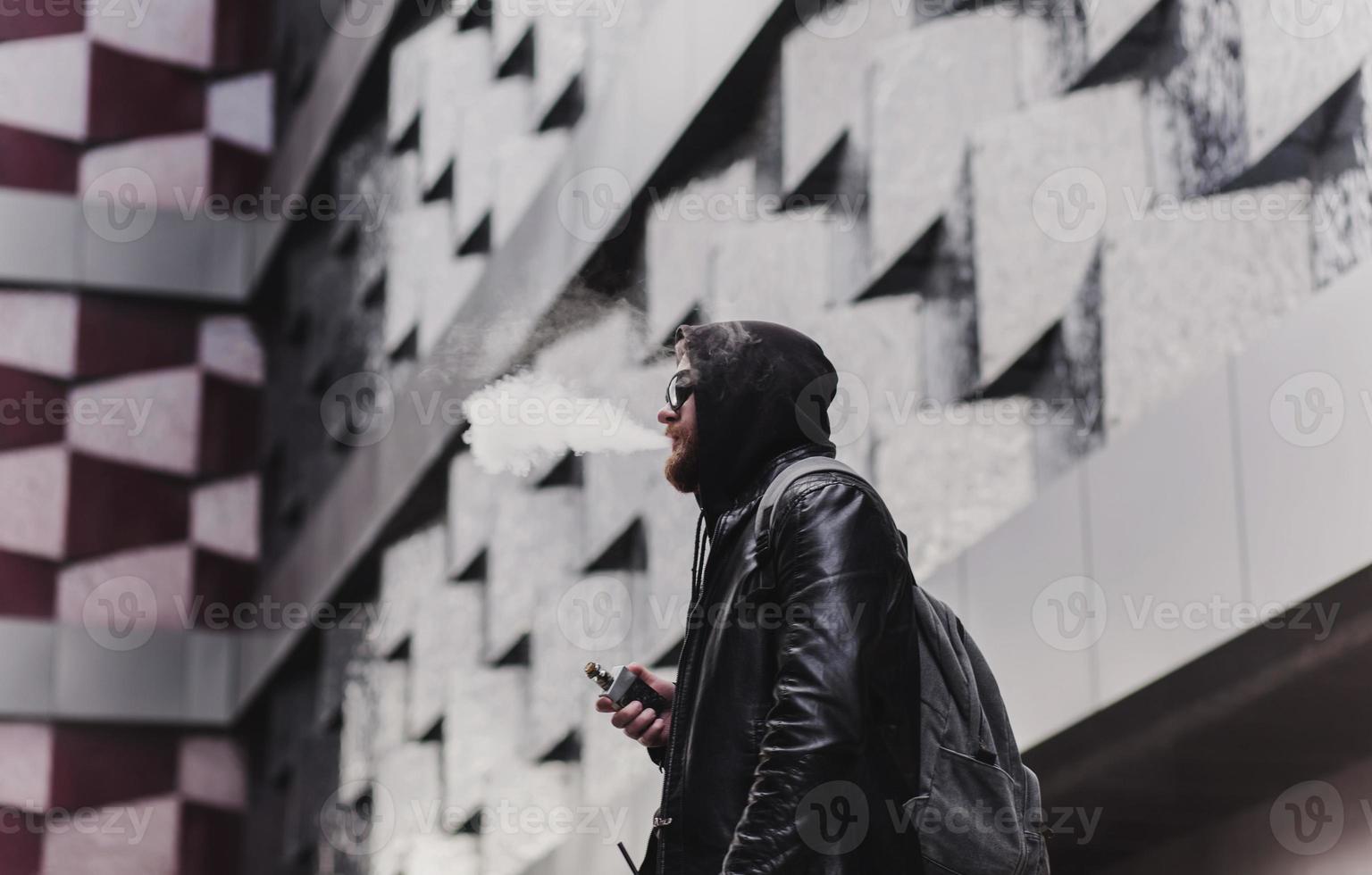 hombre vapeando y libera una nube de vapor foto