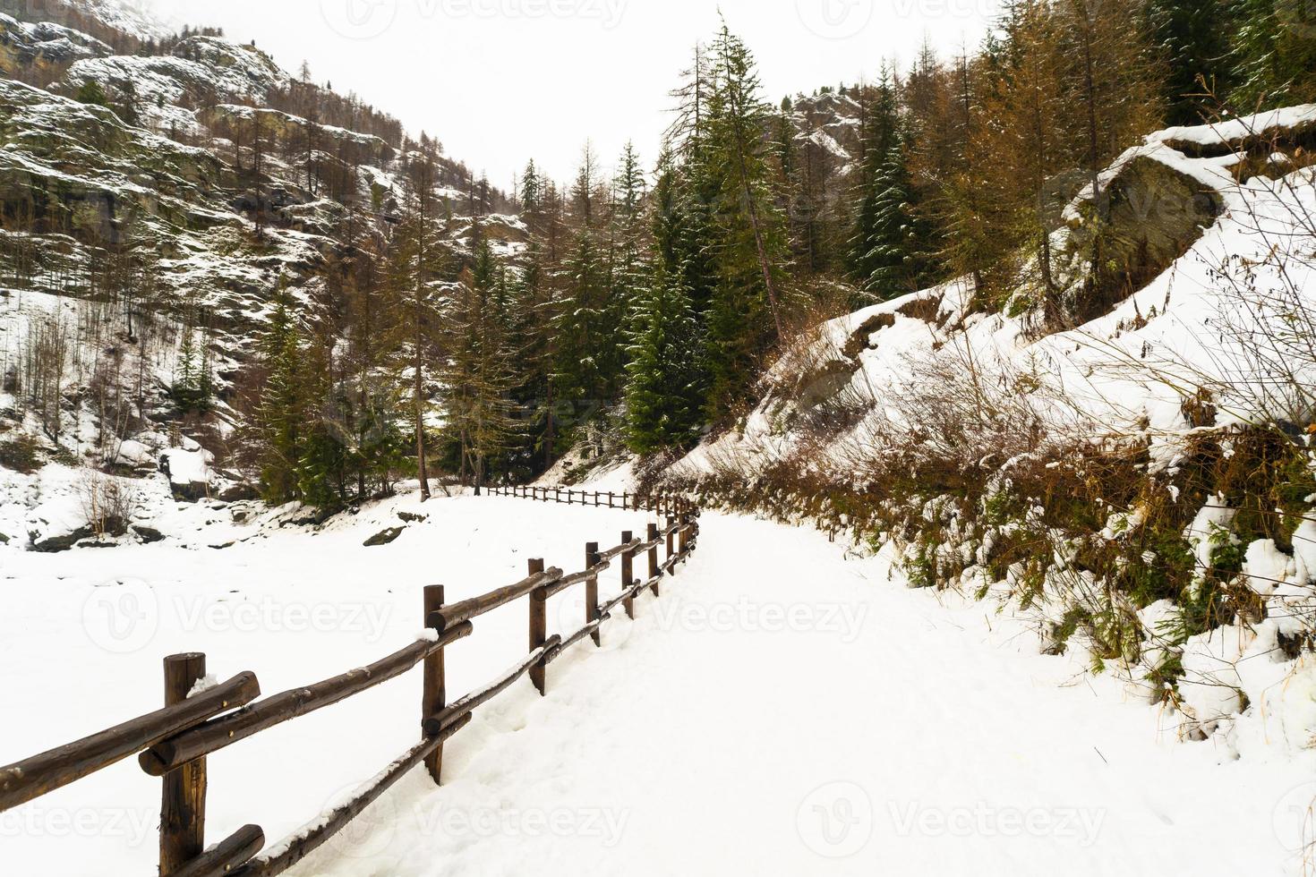 una pasarela de montaña a lo largo de un lago congelado foto