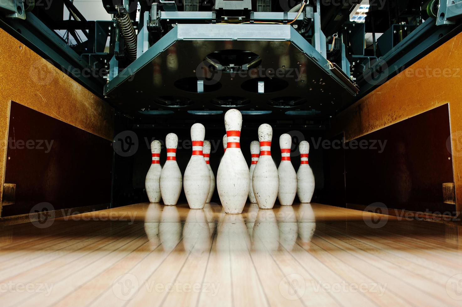 Ten white pins in a bowling alley lane photo