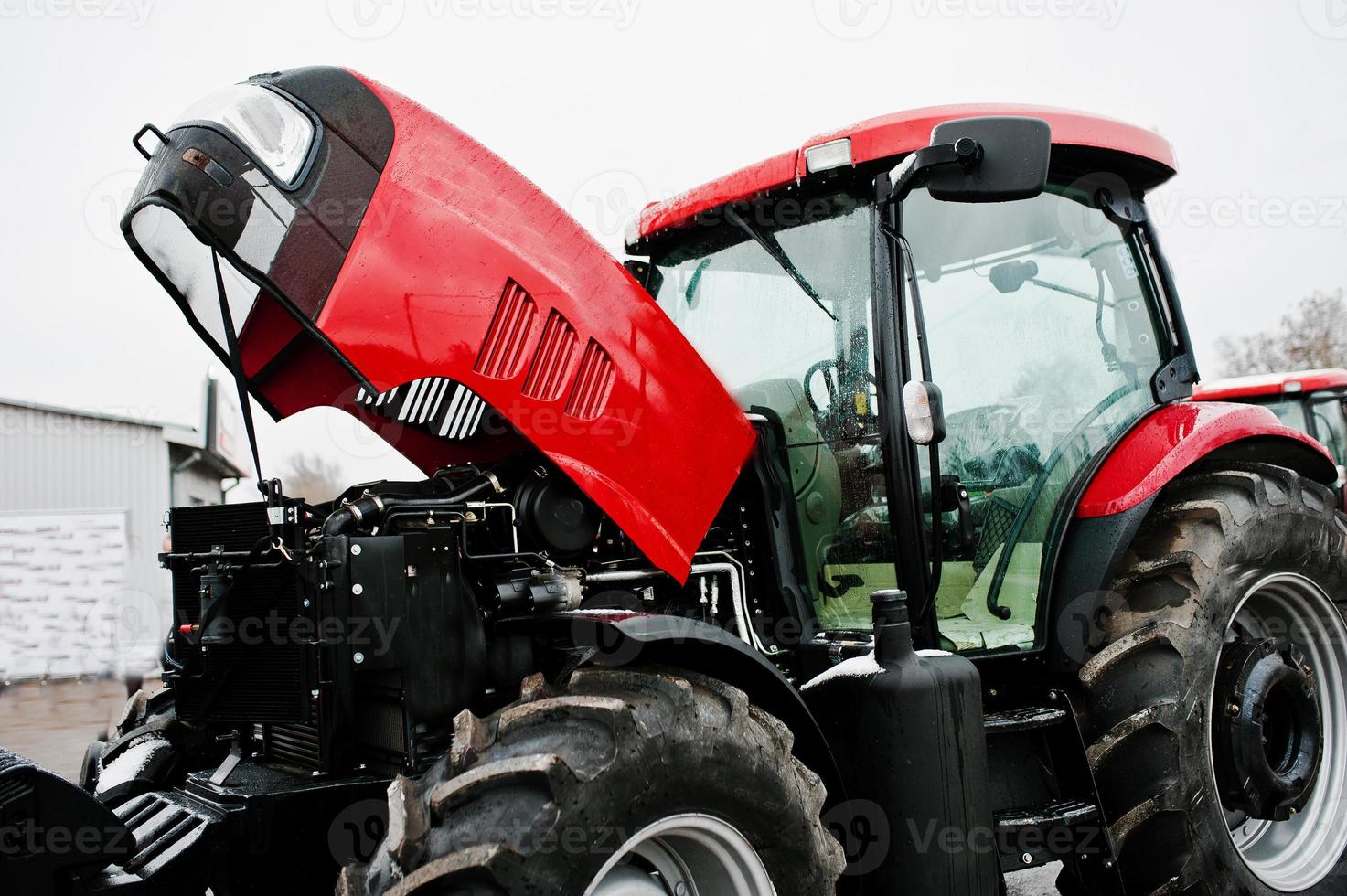 Close up in front of the new red tractor with open motor photo