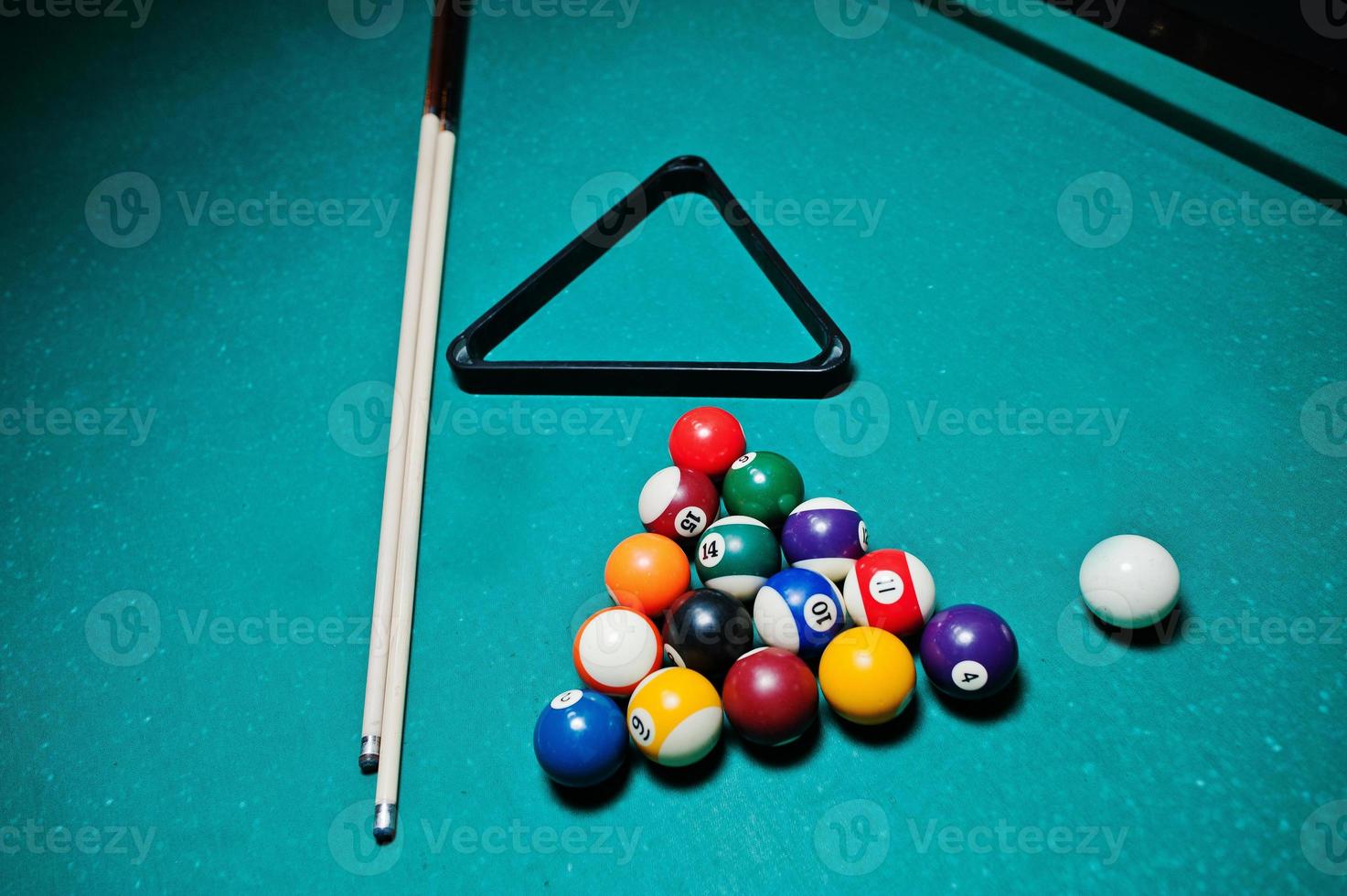 Billiard balls in a pool table at triangle with billiard cue photo