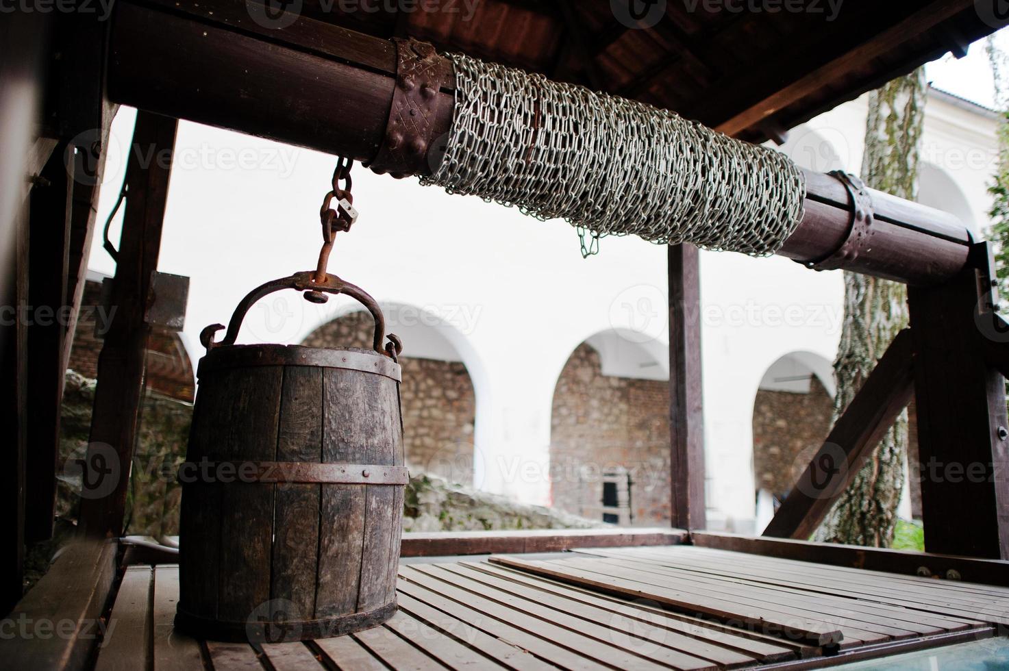 Old wooden water well with pulley and bucket. Palanok castle photo