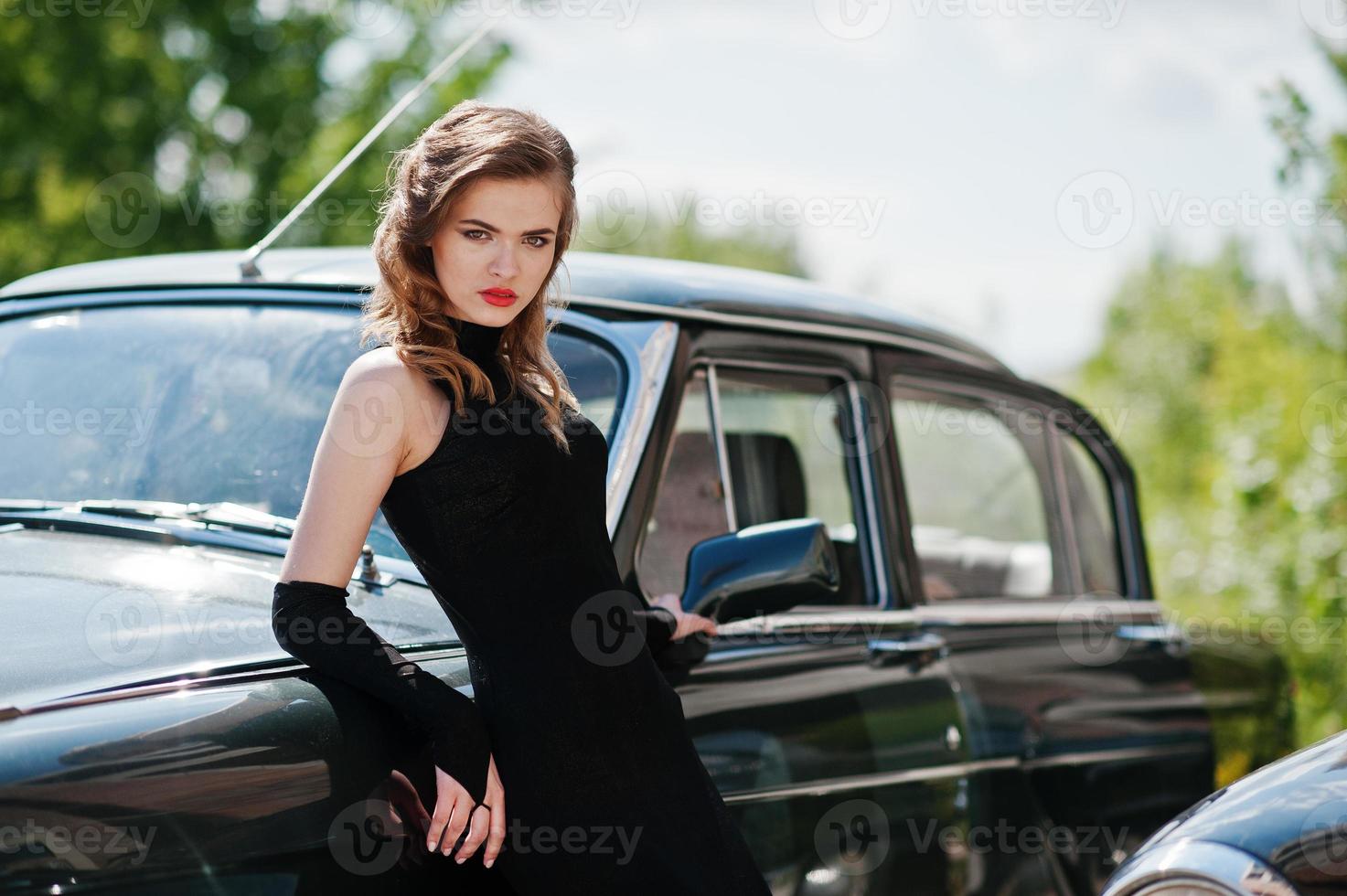 Portrait of beautiful fashion girl model with bright makeup in retro style leaned on a vintage car photo