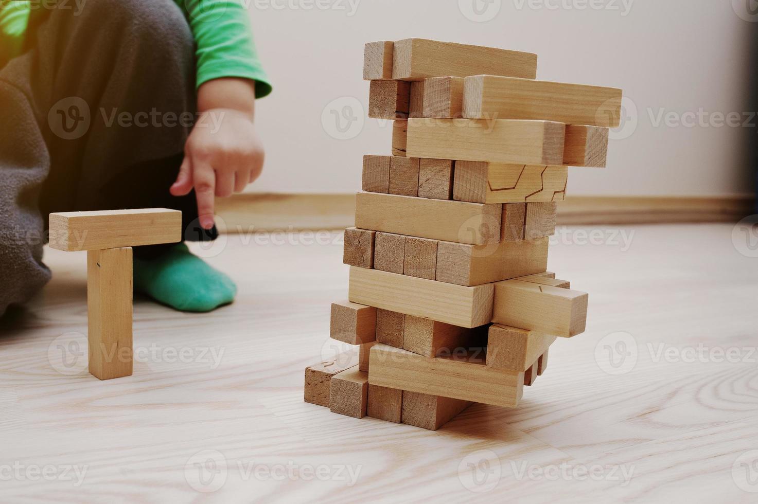 Hand of baby who played developmental game of wooden blocks lumber photo