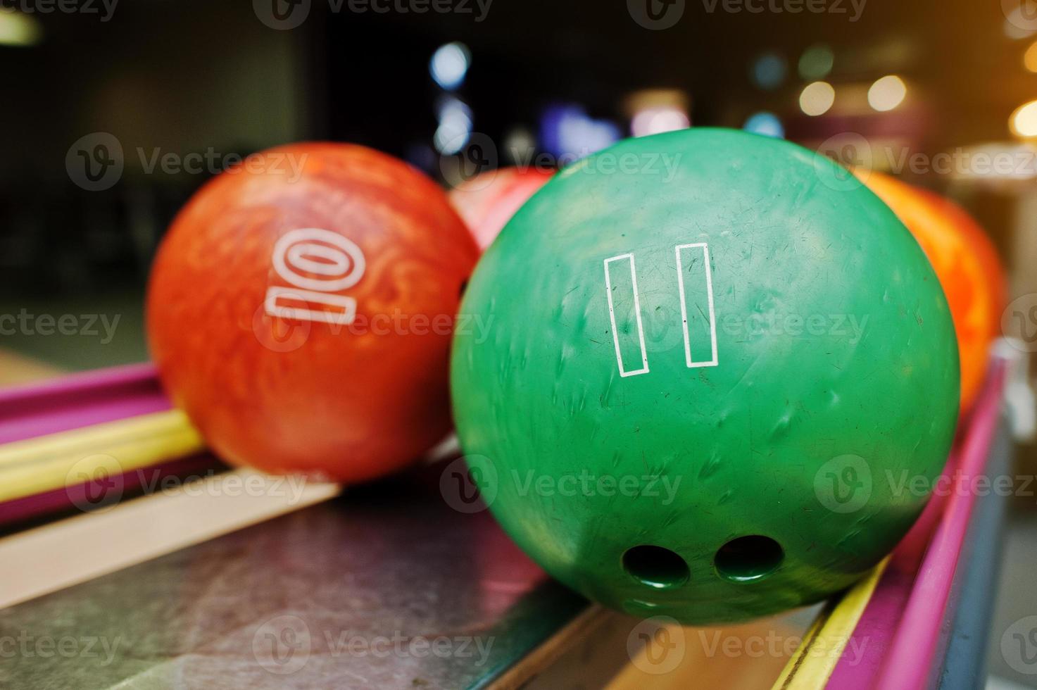 Two colored bowling balls of number 11 and 10 photo