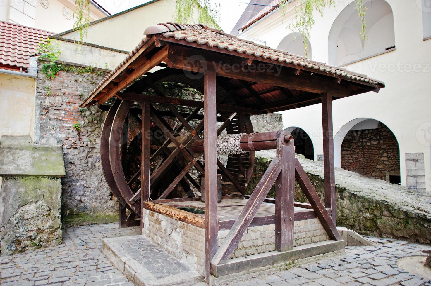 Old wooden water well with pulley and bucket. Palanok castle photo