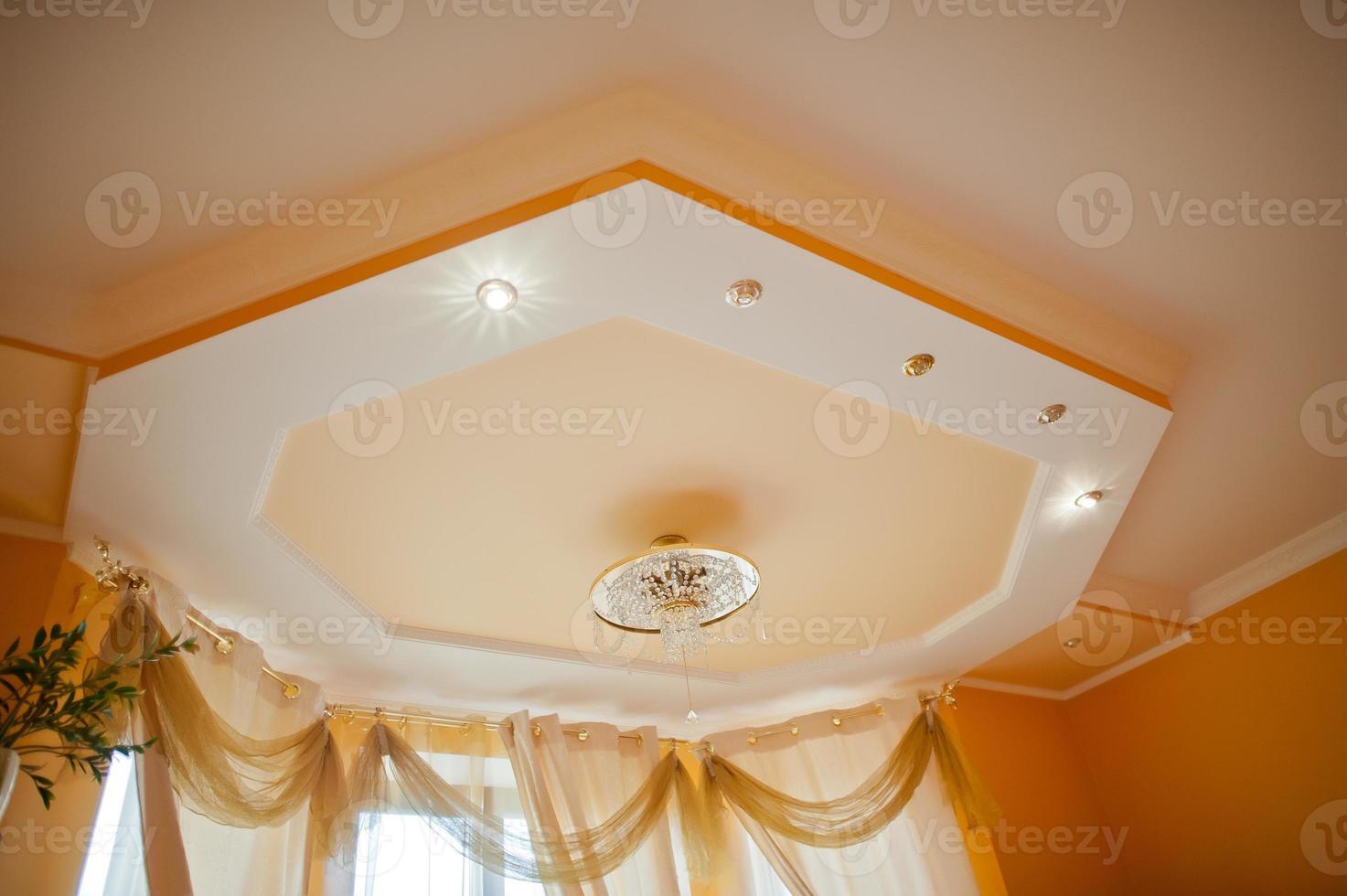 Golden and mirror chandelier with point light on orange ceiling photo