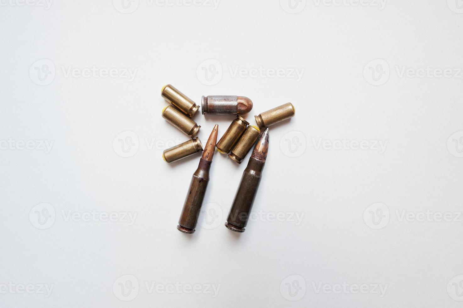 Rifle and pistol bullets on white background photo