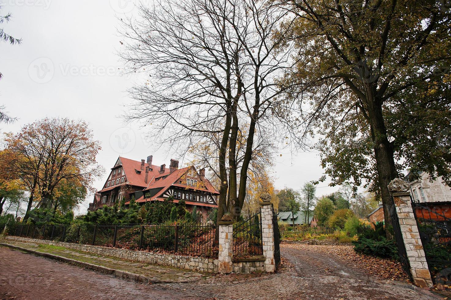 Gate court autumn yard of old gothic mansion photo