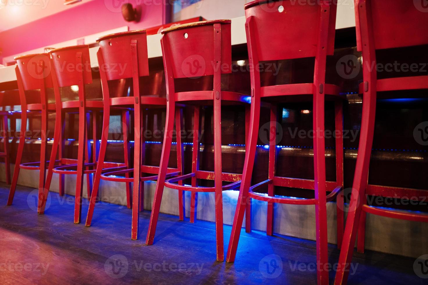 Red bar stools at diode color light photo