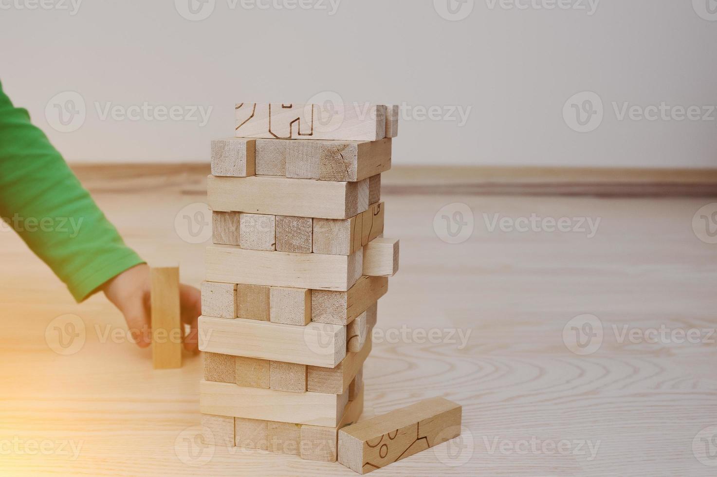 Hand of baby who played developmental game of wooden blocks lumber photo
