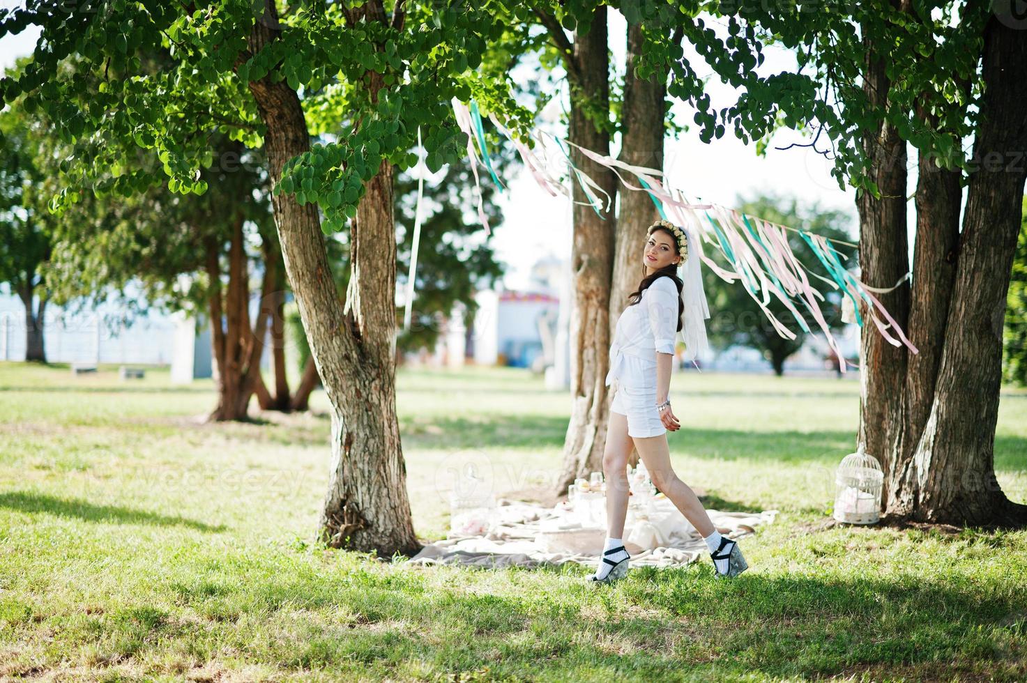 Unmarried girl with veil on had posed background picnic table and decor at bachelorette party photo
