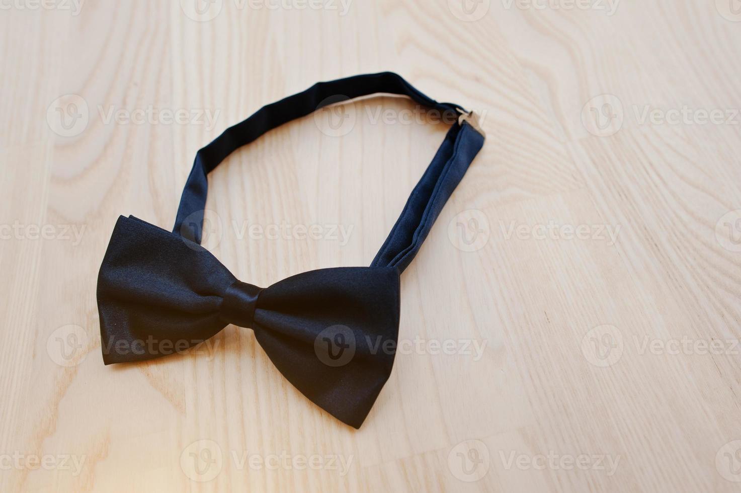 Silk blue bow tie on light wooden background photo