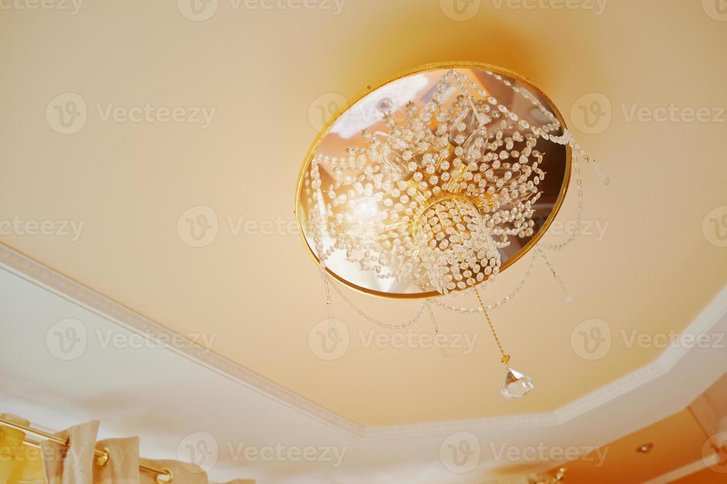 Golden and mirror chandelier with point light on orange ceiling photo