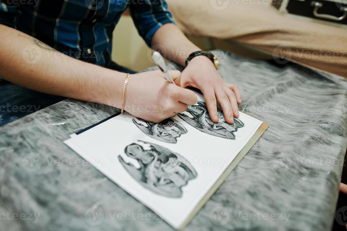 maestro del tatuaje preparando boceto para tatuaje foto