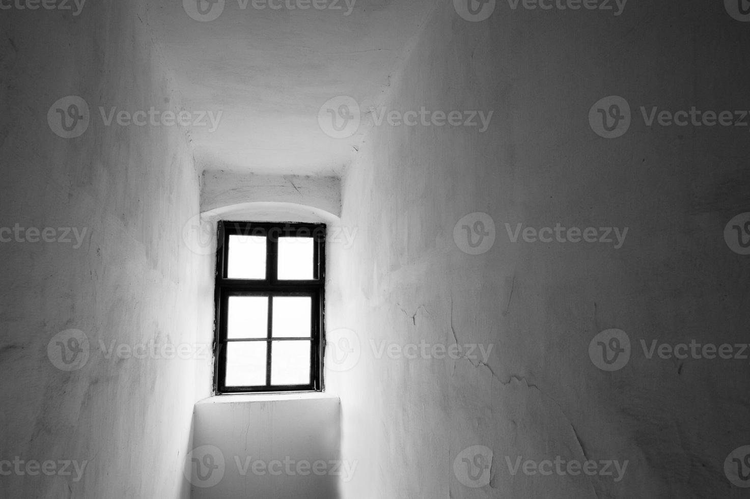 Narrow space with one antique window. Scary black and white background photo