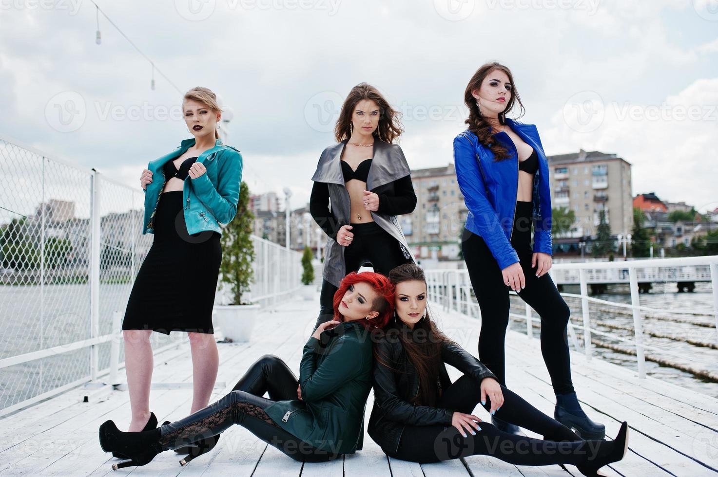 grupo de chicas sexy modelos en sujetador negro y chaquetas de cuero en el muelle foto