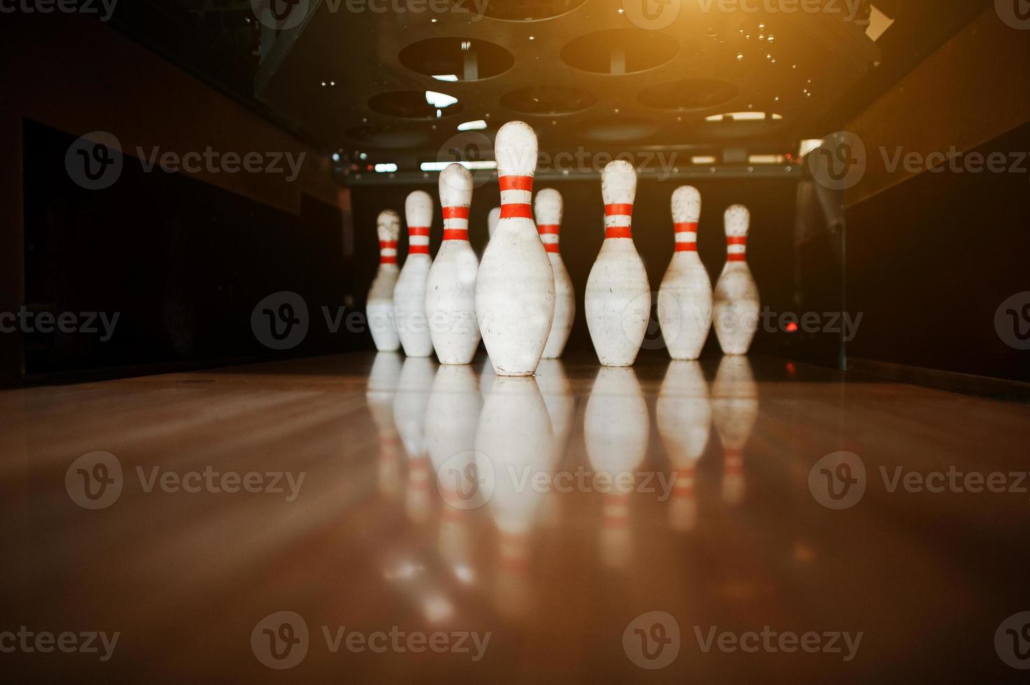 Ten white pins in a bowling alley lane photo