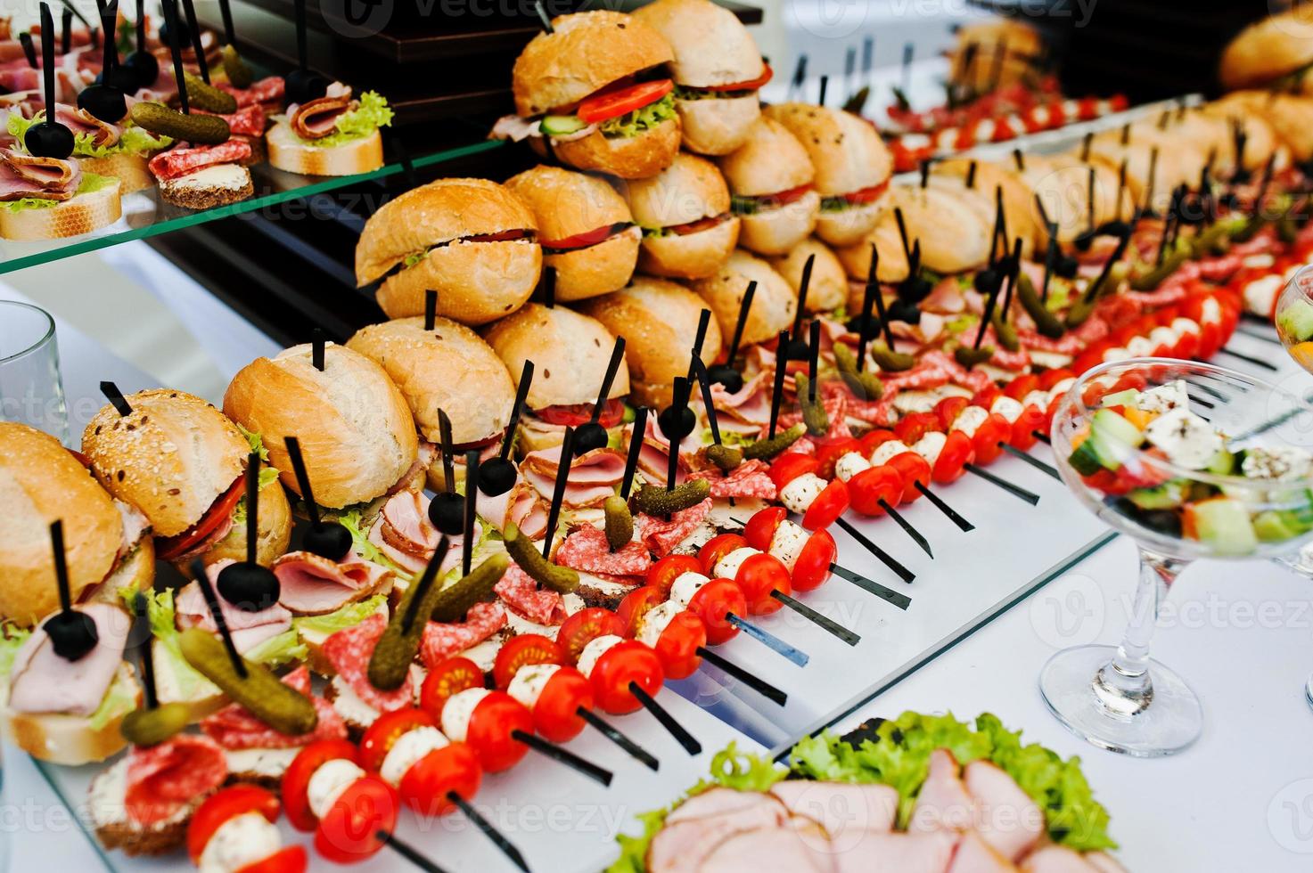 Buffet table of reception with burgers, cold snacks, meat and salads photo