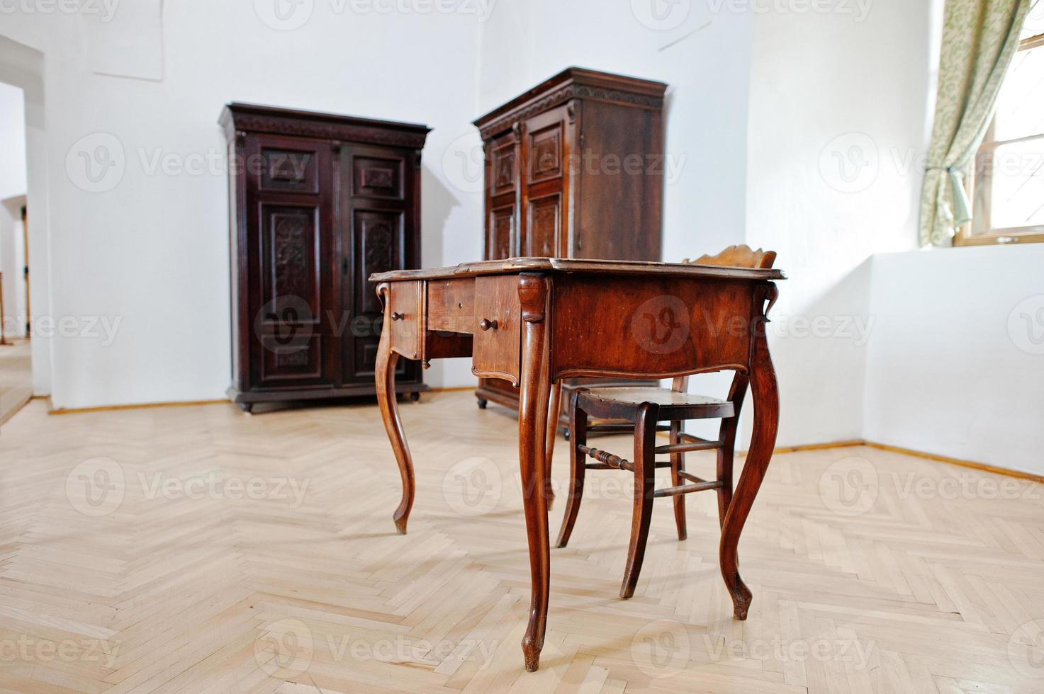 Antique wooden table and chair background of wardrobes photo