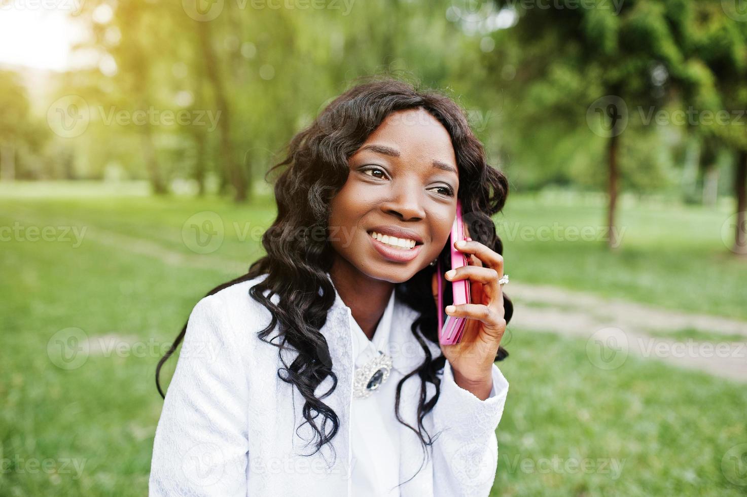 primer plano retrato de elegante chica afroamericana negra con teléfono móvil rosa foto