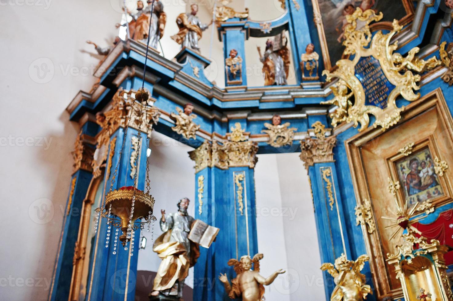 Chandelier in church background golden statue of angels and icon of Holy Mary at iconostasis photo