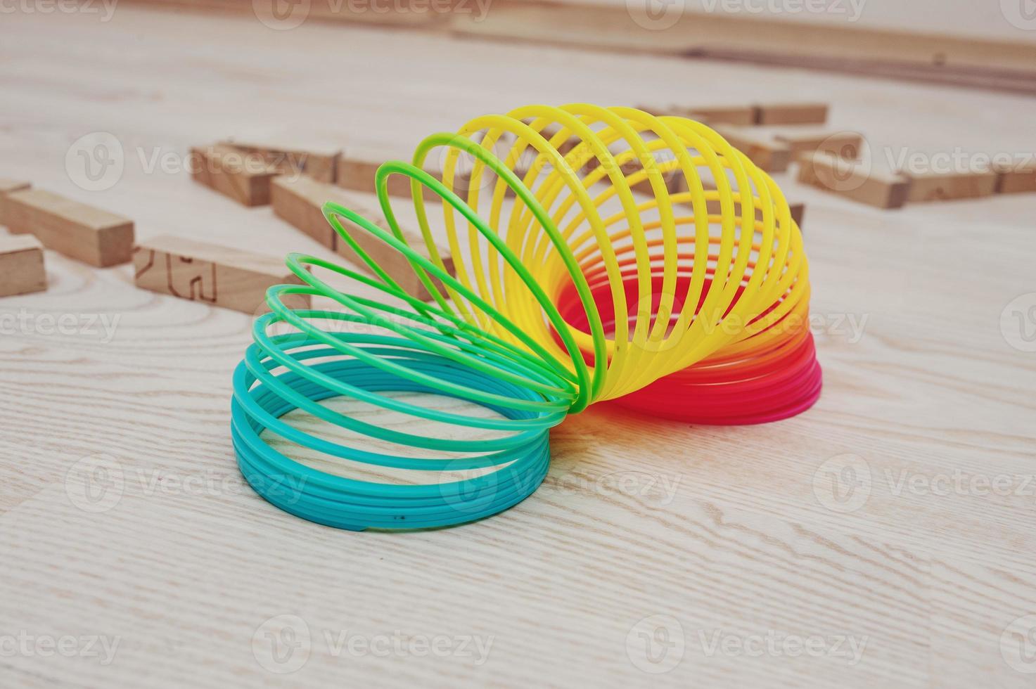 Rainbow spiral spring game on wooden background photo