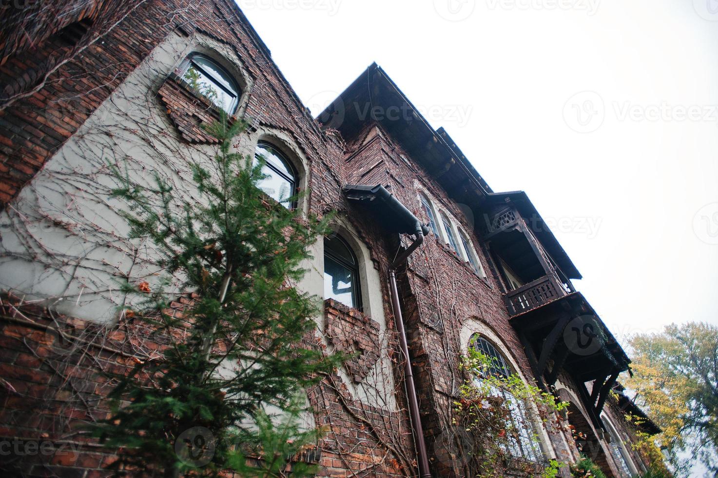 Old abandoned brick  mystic mansion. Gothic building at autumn photo