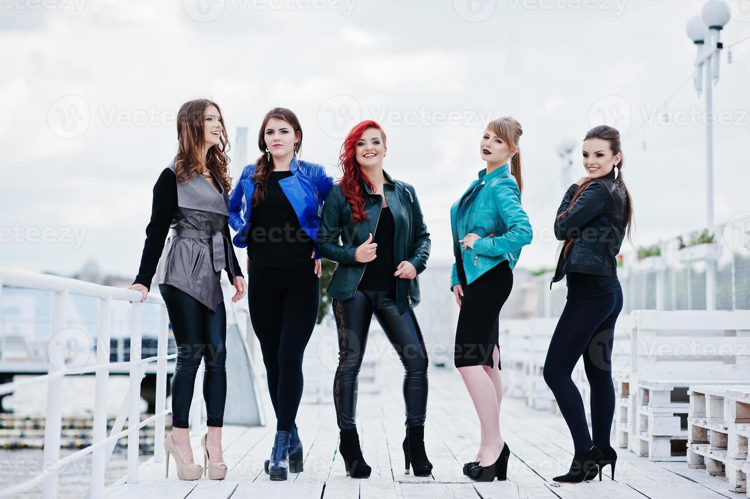 Five beautiful young girls models at leather jackets posing on berth. photo