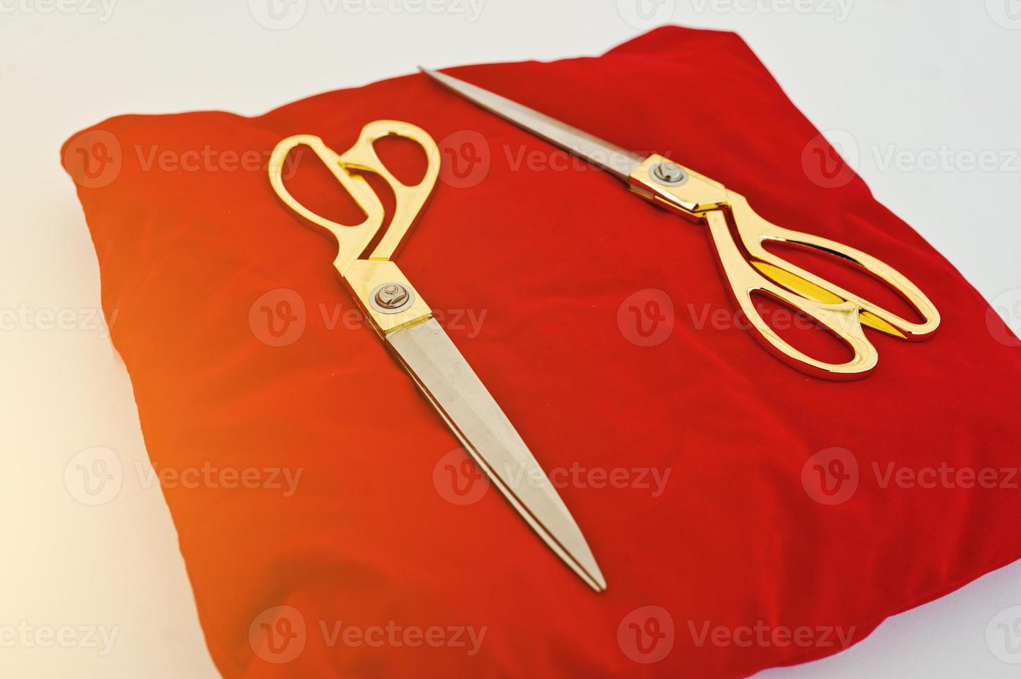 Gold scissors on a red silk cushion for grand opening photo