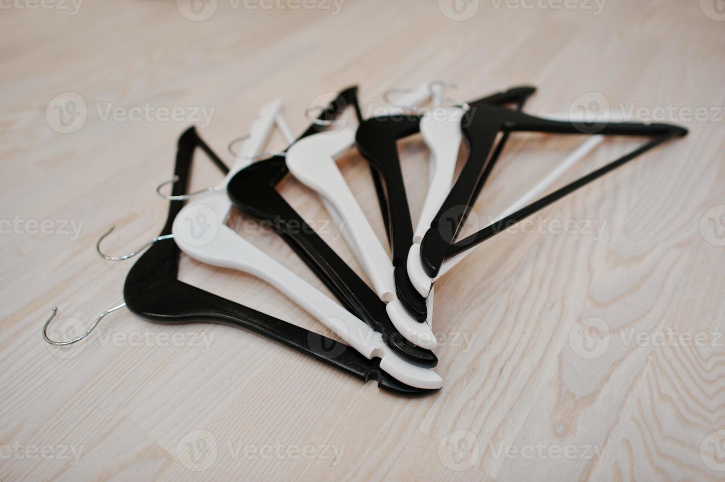 Black and white hangers on light wooden background photo