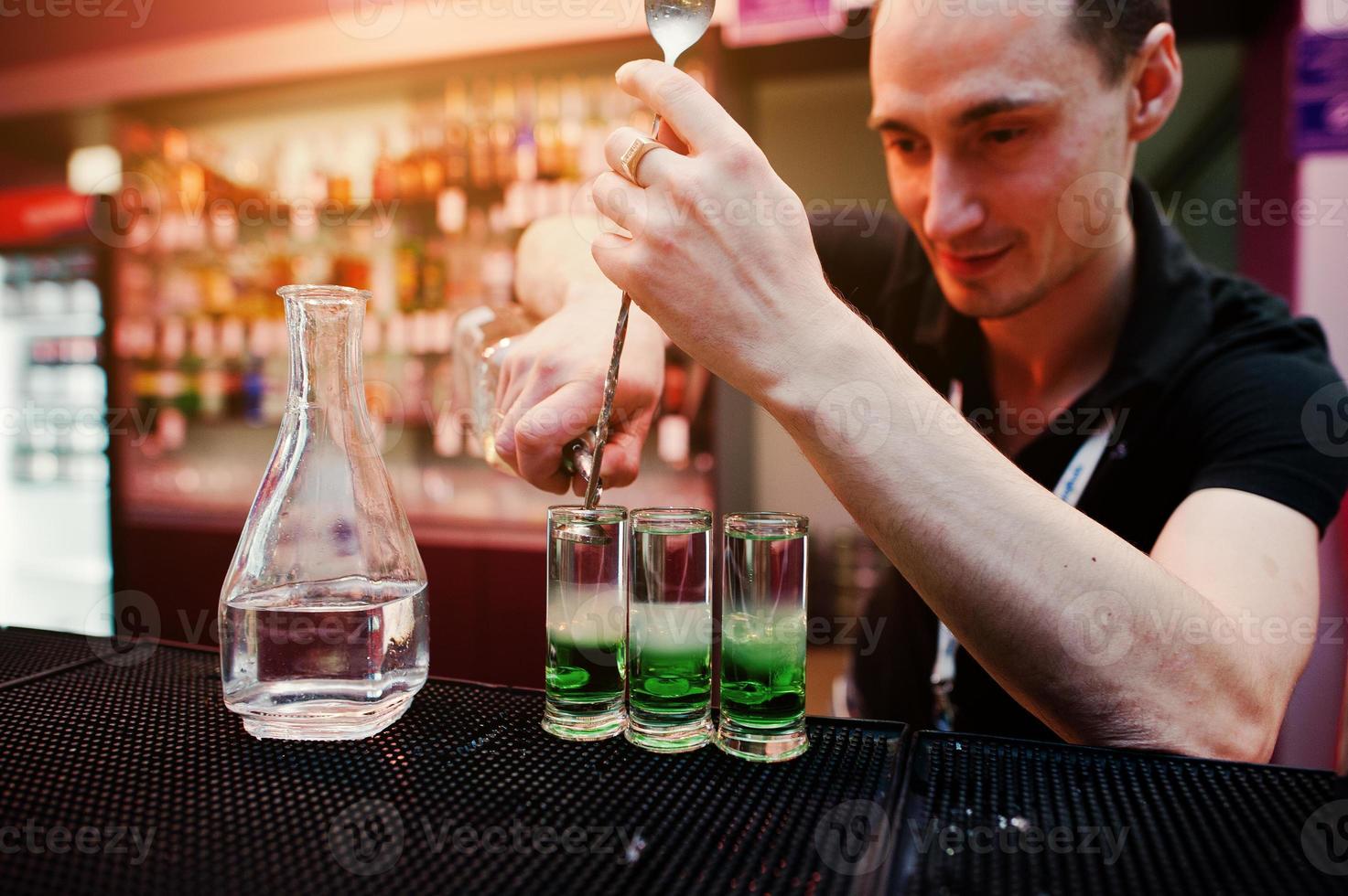 Barman preparing green mexican cocktail drink at the bar photo