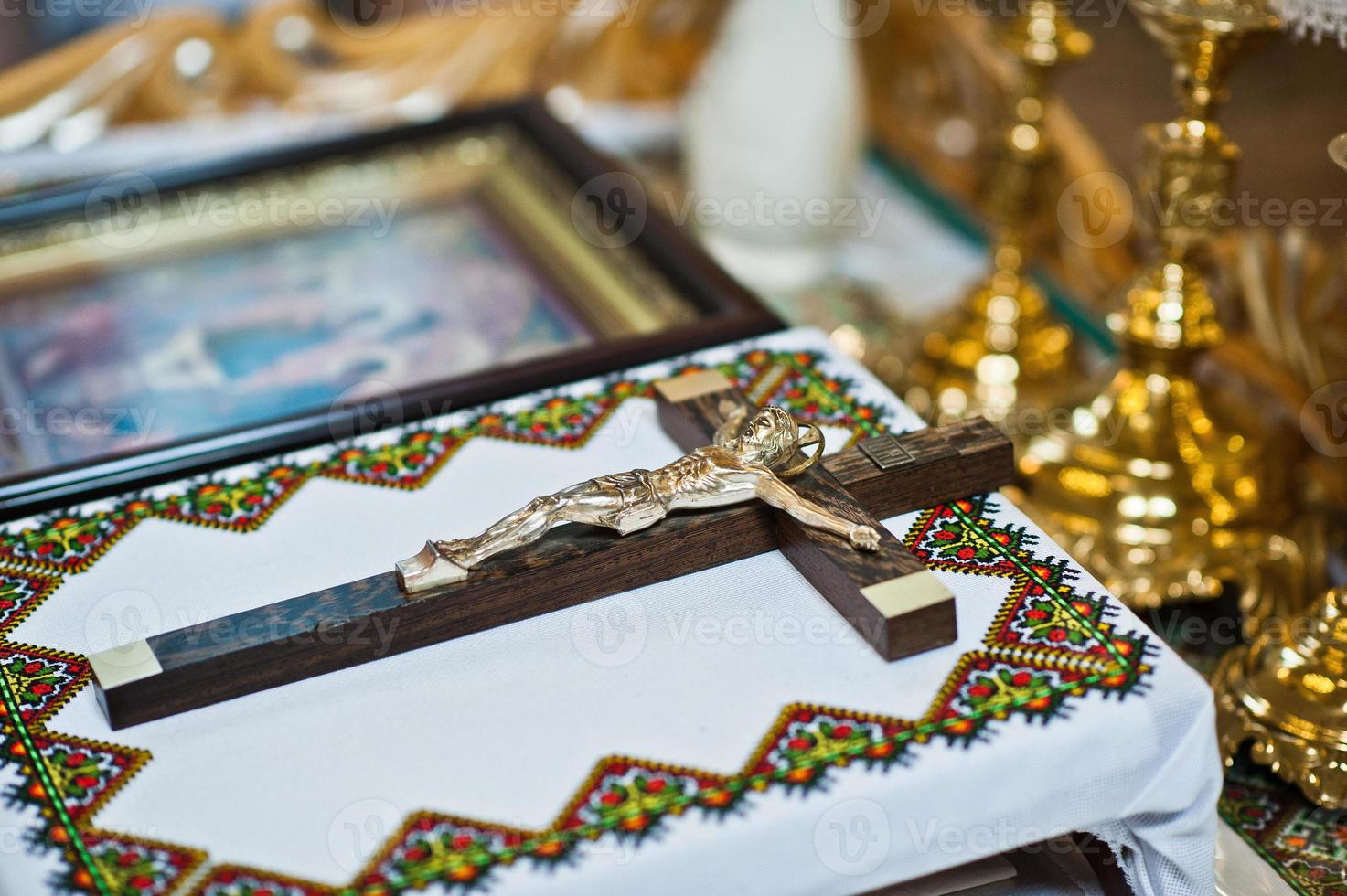 Catholic wooden cross with a crucifix on table at church photo