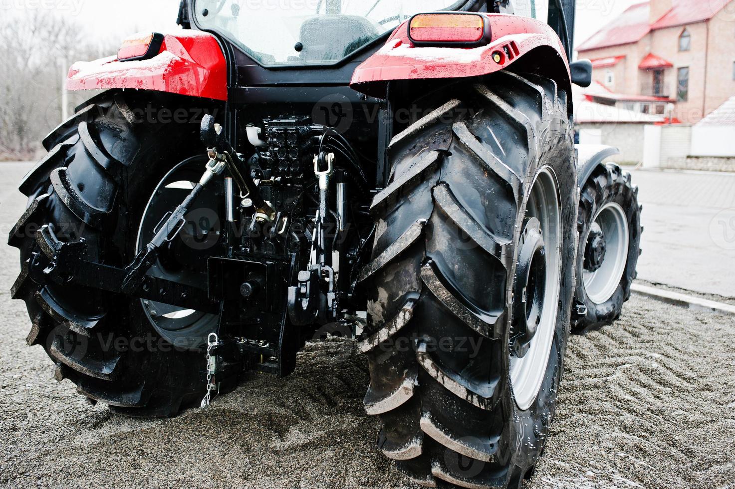 Wheels of back view of new tractor in snowy weather photo