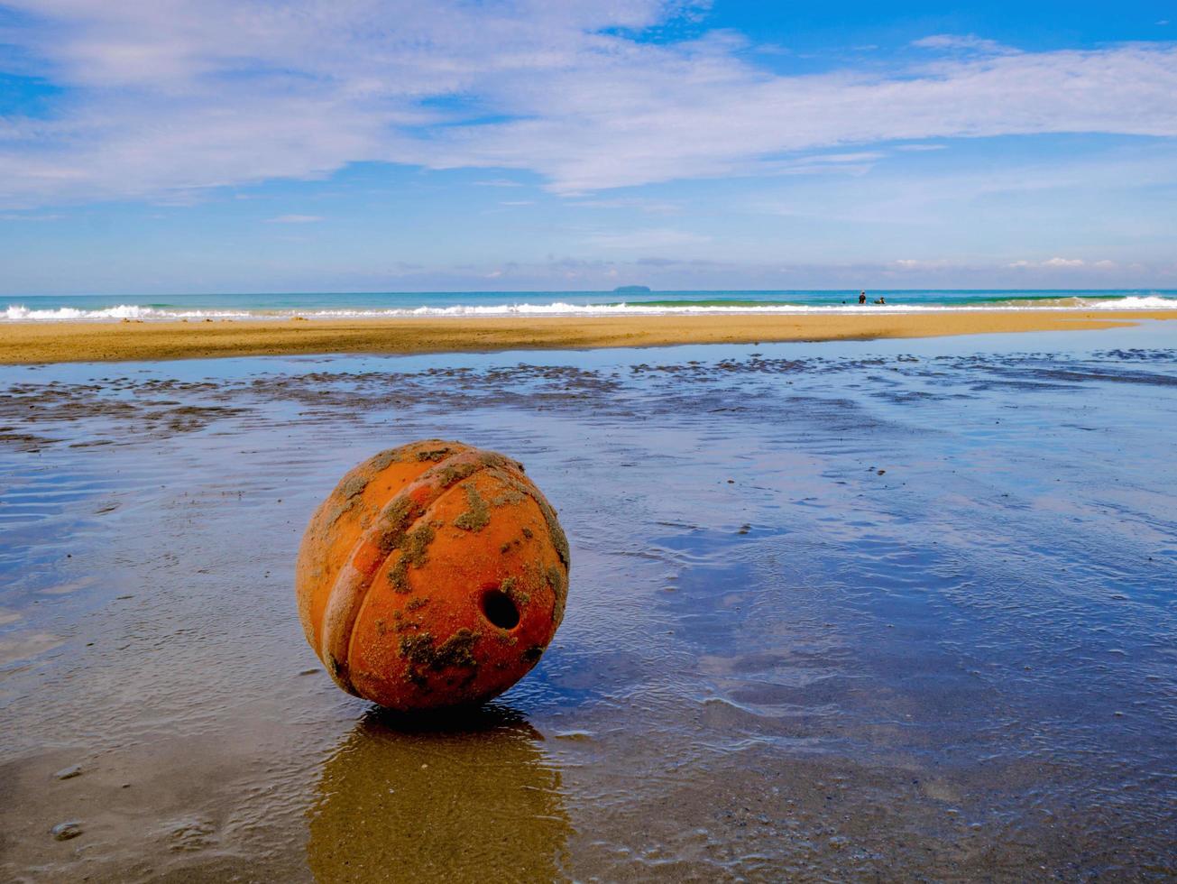 Old and Dirty Buoy Ball on the Beach in vacation time,Holiday with idyllic ocean,Summer concept photo