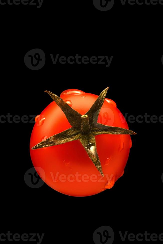 Cherry tomato in water drops isolated on black background. photo